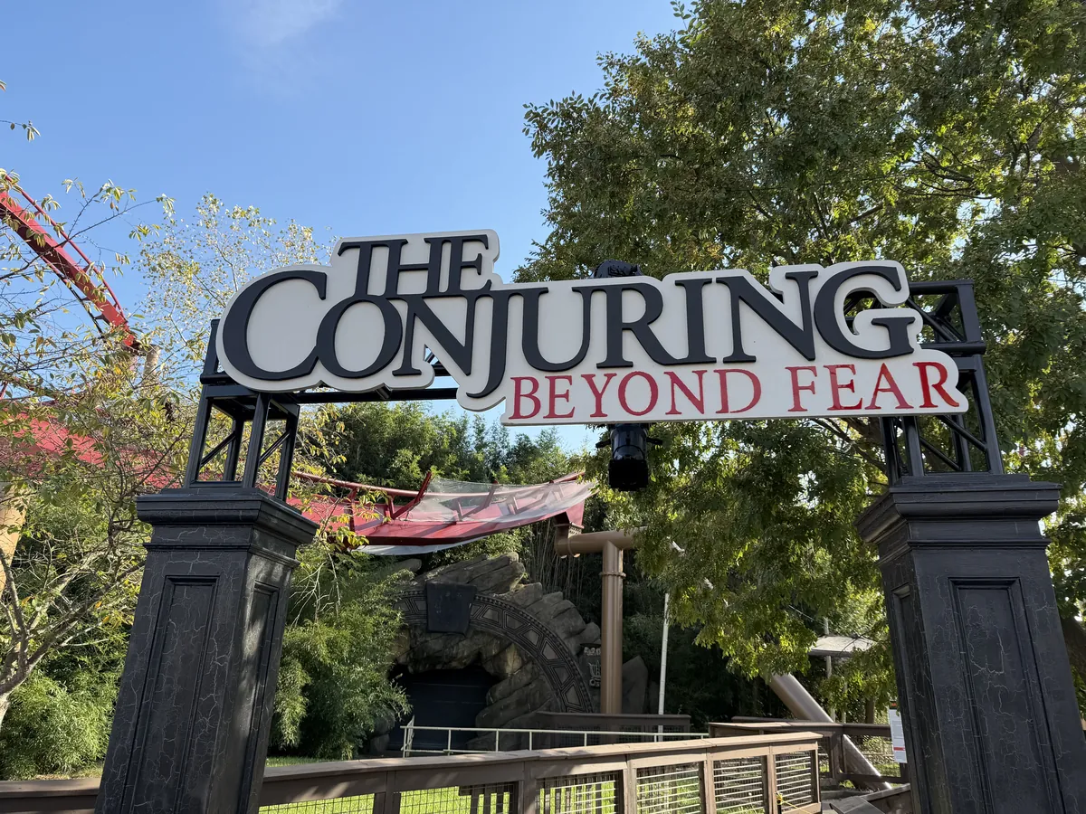 The Conjuring: Beyond Fear entrance arch at Kings Island, with coaster track behind it